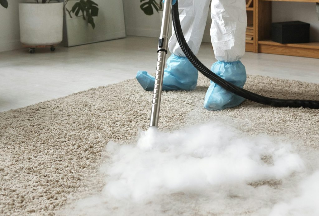 Nettoyage vapeur d’une moquette par un opérateur en combinaison