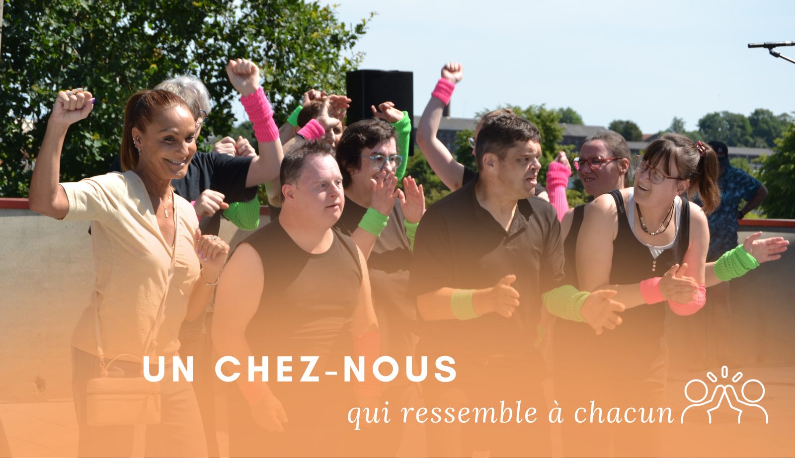 Résidents et accompagnants bras levés, en fête, un chez-nous qui ressemble à chacun