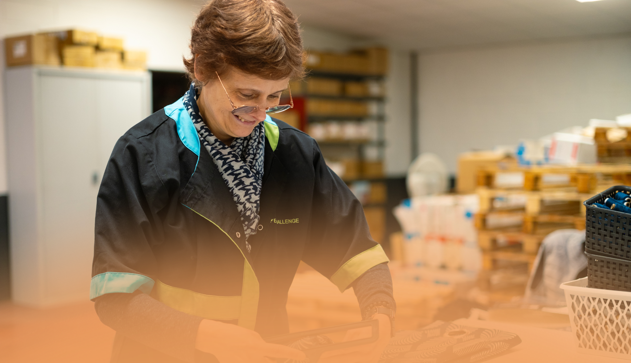 Salariée de l’entreprise adaptée Challenge, en blouse siglée, à son poste en atelier
